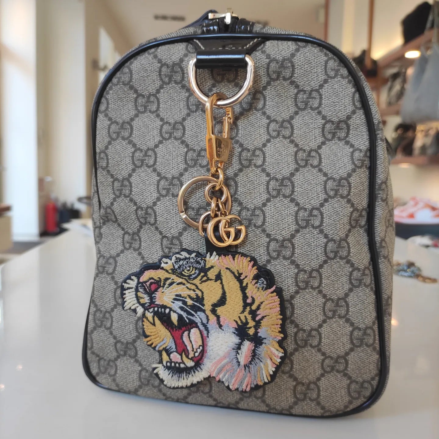 Charm o portachiavi Gucci Tiger in metallo, tela GG supreme e finiture in pelle nera
